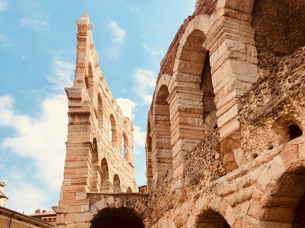 Close-up of ancient stone arches beneath a blue sky