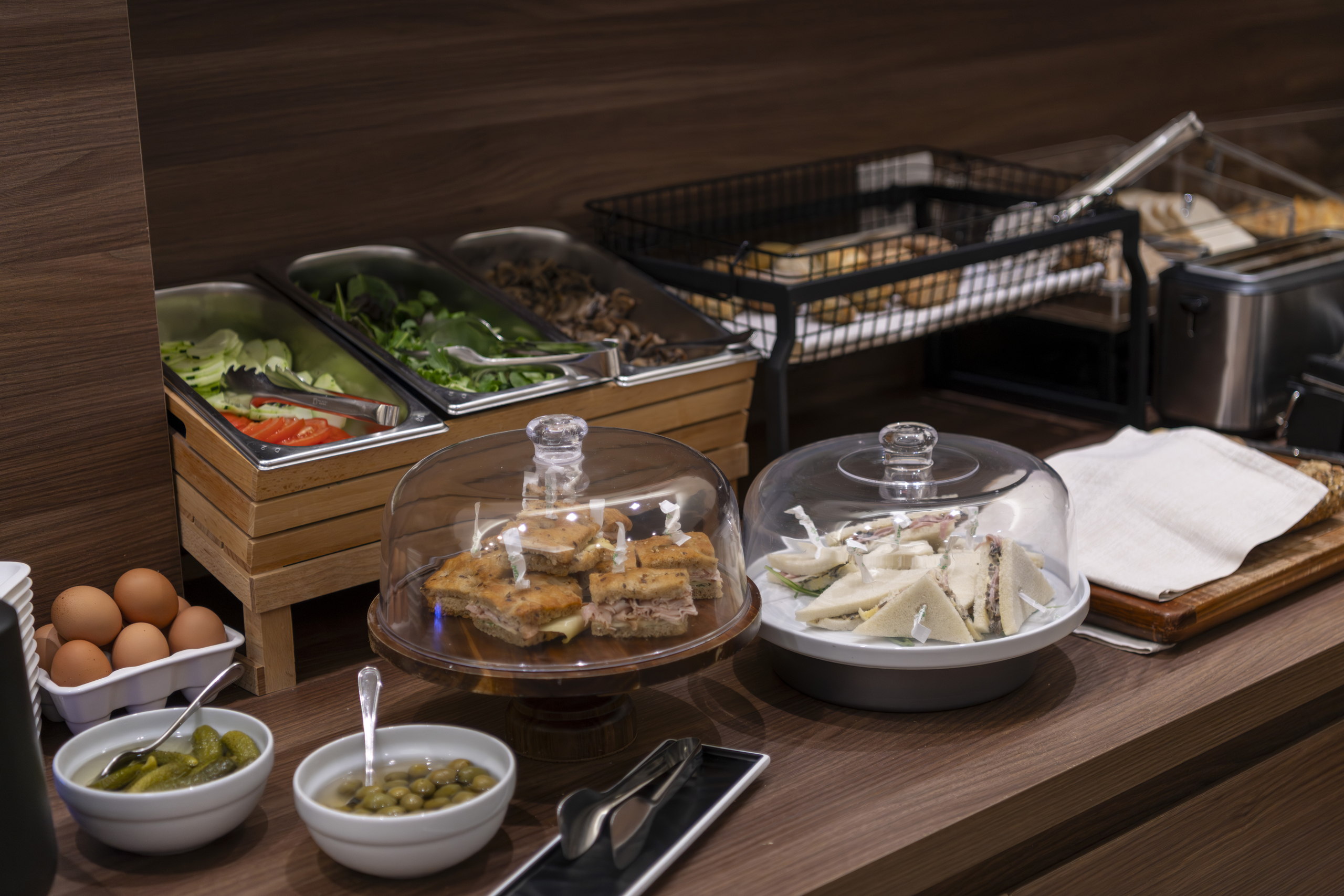 Buffet counter with salads, sandwiches, cheese, eggs, pickles and olives